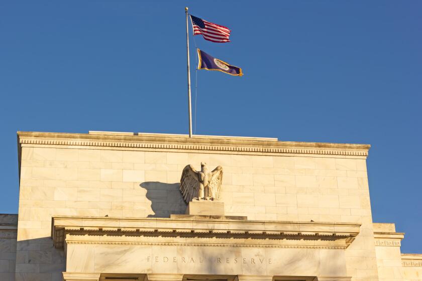 United States Federal Reserve headquarters in Washington DC, USA. Eccles Building with US National and Fed flags under clear sky in early morning.
