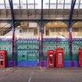Red phone boxes next to the colourful fence of Smithfield Market