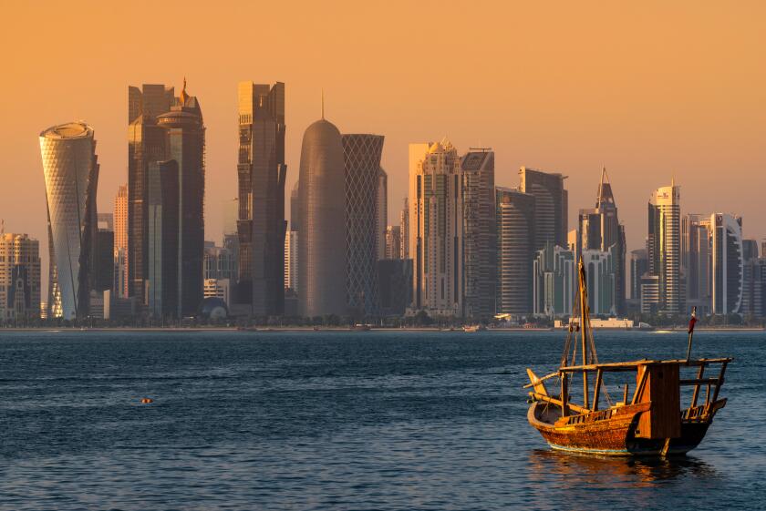 Dhow traditional sailing vessel with the financial area skyline behind, Doha, Qatar