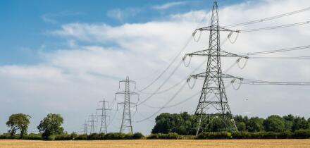 National Grid power lines cross arable fields near Nettleton in England's Cotswolds Hills.