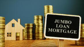 Jumbo Loan mortgage inscription and stacks of coins.