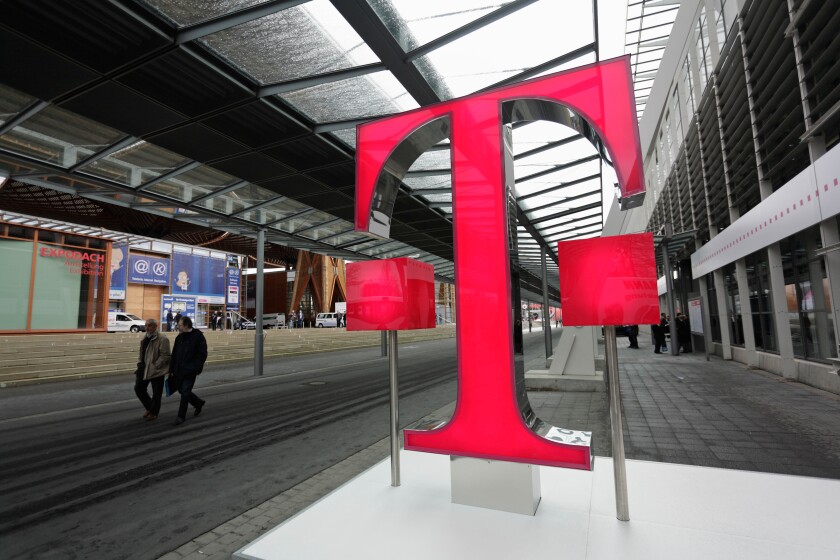 Germany Hanover  2008 - Fairgoers walk past logo of German telecommunications giant Deutsche Telekom at CeBIT Trade Fair