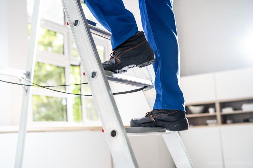 Low Section View Of A Handyman's Foot Climbing Ladder