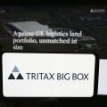 Stuttgart, Germany, 05-29-2024: Person holding cellphone with logo of British property company Tritax Big Box REIT plc in front of business webpage. F