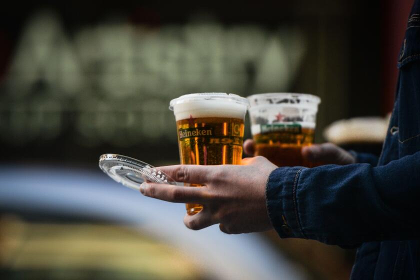 A person walks with a take away beers on St. Patrick's Day as public events in Ireland were cancelled due to Level 5 Covid-19 lockdown. On Wednesday, 17 March 2021, in Dublin, Ireland. (Photo by Artur Widak/NurPhoto)