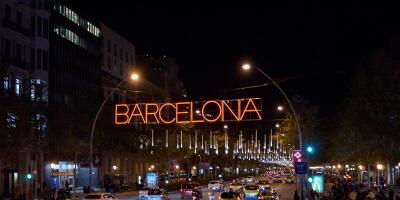 Barcelona. Spain - January 14, 2026: Night traffic on an iconic Barcelona street with taxis and decorative city lights.