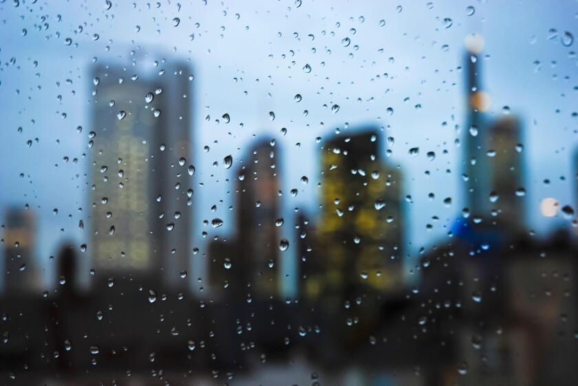 Frankfurt skyline at night seen through a window with rain drops