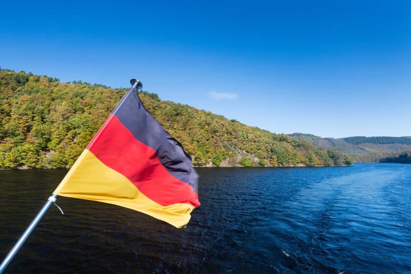 German flag on a boat on Lake Rursee with blue sky and sunlight in summer.