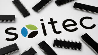 SOITEC company logo on the paper document and large microchips placed around. Illustrative for electronic chip manufacturer.  Selective focus. Staffor