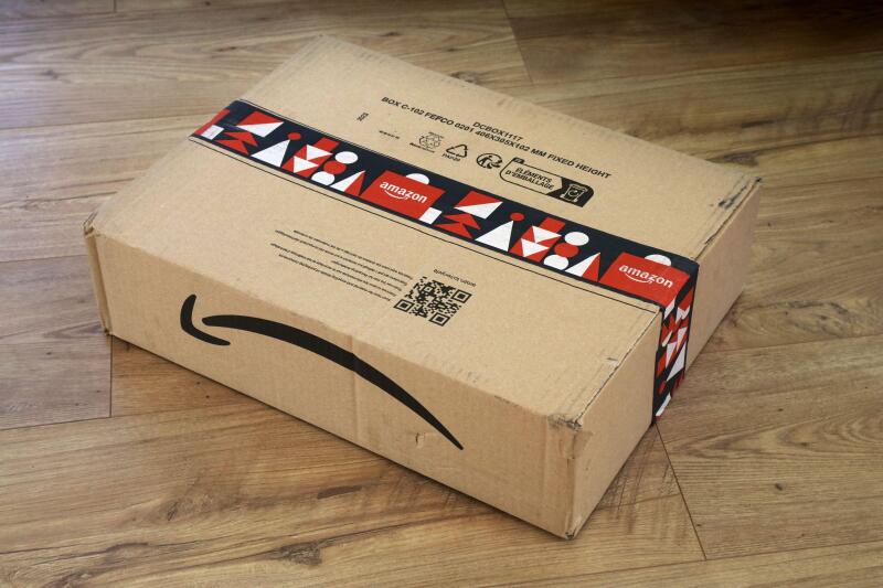 WARSAW, POLAND - DECEMBER 18, 2023: Amazon online store order box package delivered in Europe before Christmas, with holiday design tape.