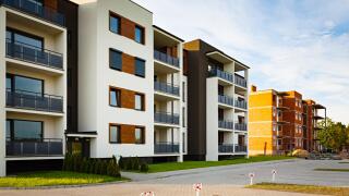 New multi-family block with balconies and bright facade decorated with wood paneling.