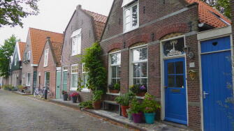Quaint village houses with blooming flowers and plants in Edam, Netherlands, showcasing traditional Dutch architecture