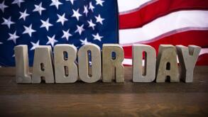 Happy Labor Day banner. USA flag and letters on rustic wooden background.