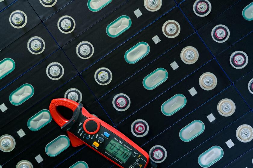 Electric vehicle lithium NMC battery with multimeter. Electric car battery manufacturing factory. Lithium-ion cell. Lithium NMC rechargeable battery.