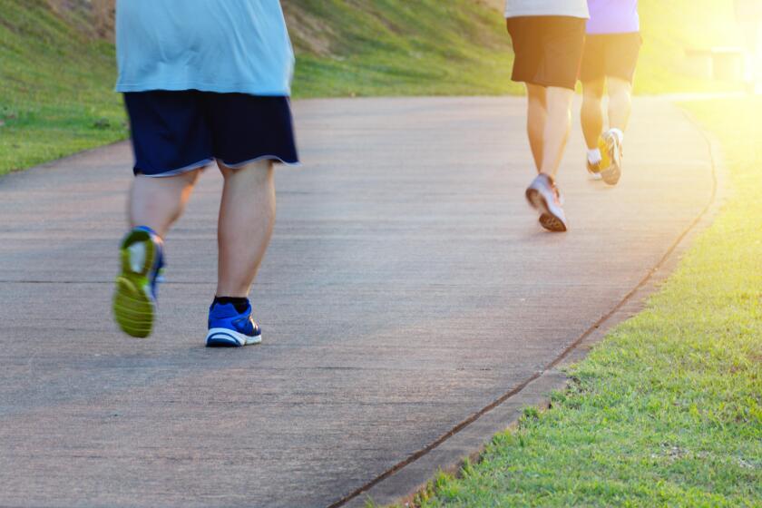 Fat man jogging, catching up with thin men. Low angle view of runners running in park. Blurred feet motion group of runners, Fitness and healthy
