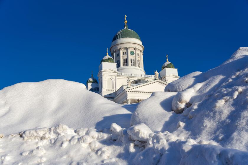 Helsinki, Finland - February 6, 2019: Helsinki Cathedral behind huge pile of snow on a sunny and cold winter afternoon after weeks of heavy snowfall