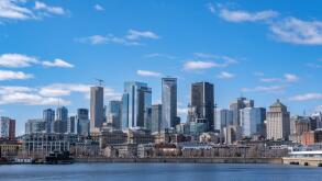 Montreal, Canada - April 4, 2025: A scenic view of Montreal's skyline from the St. Lawrence River, featuring urban architecture against a bright sky