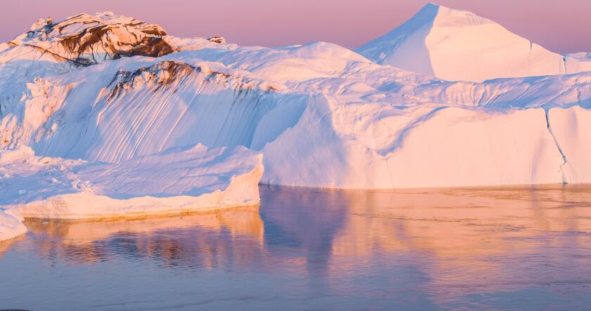 Climate Change and Global Warming - Icebergs from melting glacier in icefjord in Ilulissat, Greenland. Aerial image of arctic nature ice landscape. Unesco World Heritage Site.