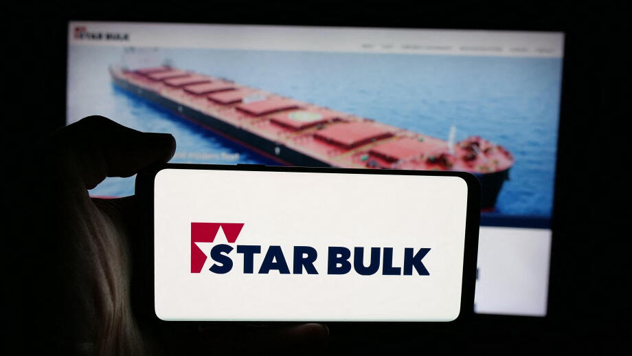 Stuttgart, Germany - 12-16-2025: Person holding cellphone with logo of shipping company Star Bulk Carriers Corp. on screen in front of webpage.