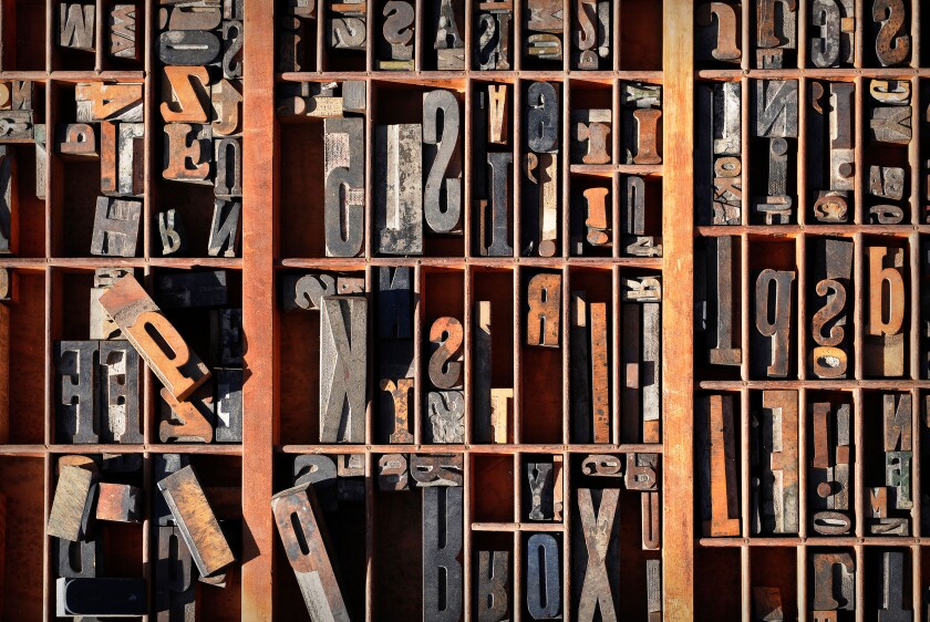 A box of old vintage printing press letter blocks in a old wooden box