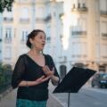Soprano sings opera on an elegant street with a music stand