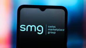In this photo illustration, the SMG Swiss Marketplace Group logo is seen displayed on a smartphone screen.