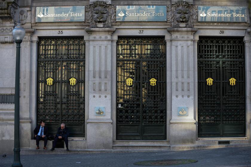 March 9, 2019 - Porto, Portugal - Men seen seating in front of Santander Totta bank..In 2018, Porto entered the list of the 100 most visited cities in the world in a ranking prepared by Euromonitor International. In 2018 it is estimated that the number of