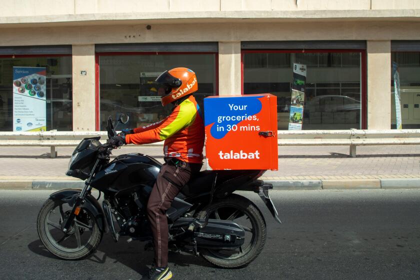 Talabat delivery rider on a motorbike delivering food in Manama, Kingdom of Bahrain, Middle East
