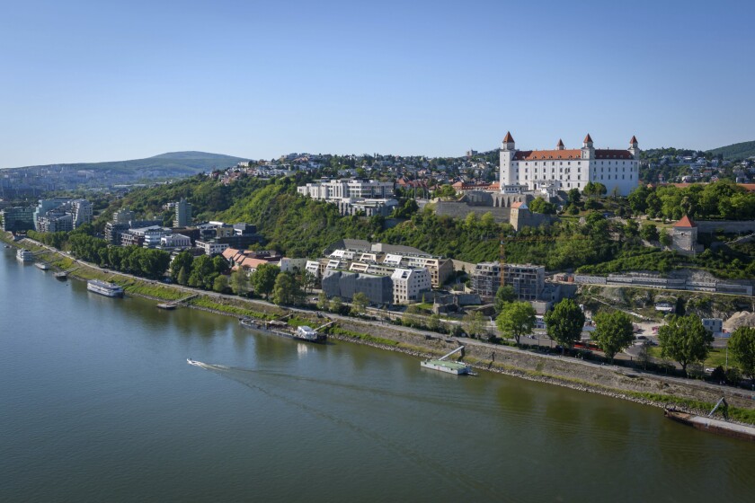 Bratislava Castle and the Old Town skyline over the Danube River, with bridge traffic and city landmarks on a clear day