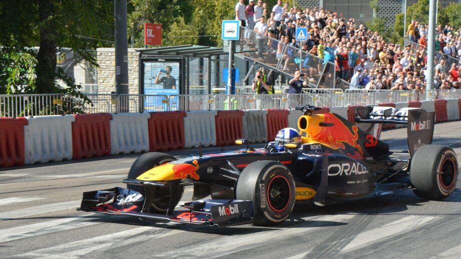 Former F1 driver David Coulthard driving the Red Bull Racing RB7 Formula 1 car during the Red Bull Showrun in Budapest, with crowds and photographers