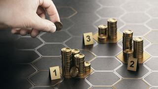 Human hand stacking generic coins over black background with hexagonal golden shapes. Concept of angel investor and investing in startup companies. Co