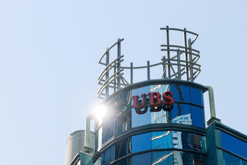 The sun glares off of a UBS Bank logo atop their Canada office in downtown Toronto; UBS is a Swiss global banking company.