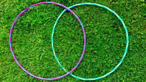 Two overlapping hula-hoops on grass. A Colorful, stylized VENN figure. Two intersecting circles. Contours. Stylish. Minimalist