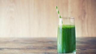 Green smoothie on vintage wooden background