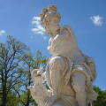 A marble statue of Mars or Ares, the ancient Roman/Greek god of war, with a dog stands in the castle garden park of Sanssouci Palace, Potsdam, Germany