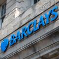 Large sign outside a branch of Barclays Bank in a city, UK.