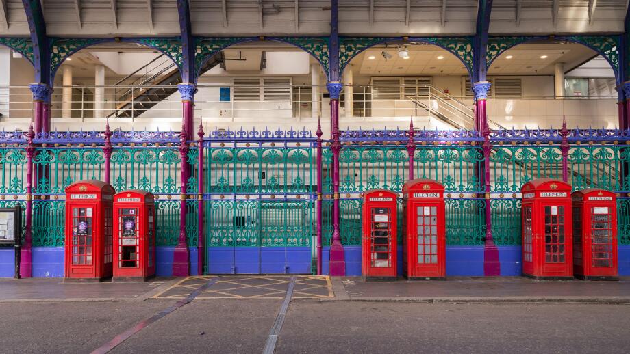 Red phone boxes next to the colourful fence of Smithfield Market