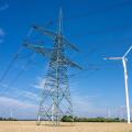 An electricity pylon with wind turbines seen in Germany