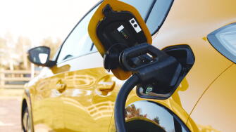 Close up of power supply plugged into an electric car being charged using a rapid charger cable