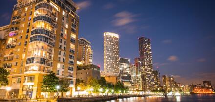 A skyline view of office and condominium towers along The Canary Wharf pier and neighbourhood at dusk.  The Thames River, London UK.