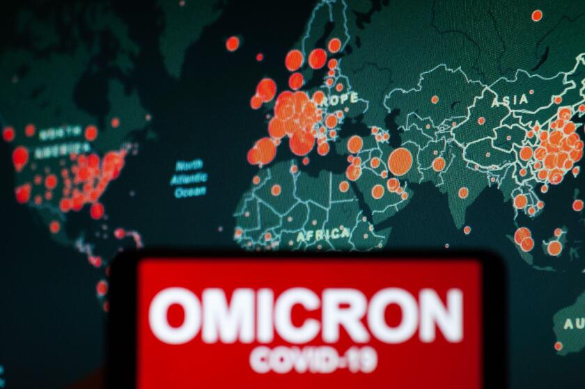 In this photo illustration, a phone screen shows a text that says Omicron COVID-19.