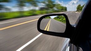 car driving through the empty road and focus on mirror