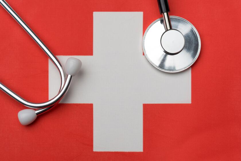 Swiss flag and stethoscope. The concept of medicine. Stethoscope on the flag in the background.
