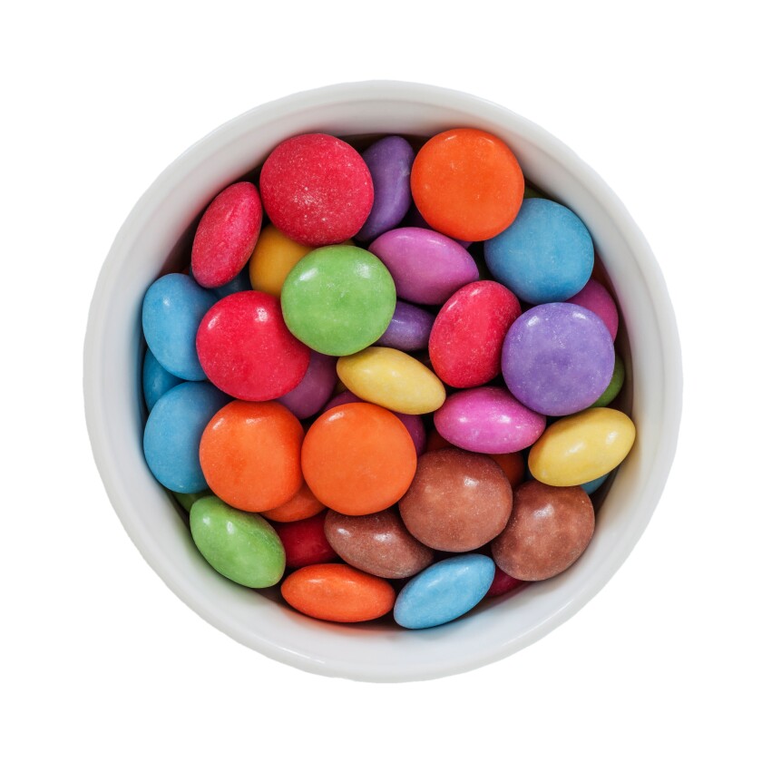 A bowl of Nestle smarties on a white background