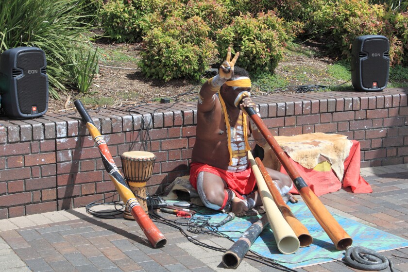 Aborigine busker playing didgeridoo entertains at Circular Quay, The Rocks, Sydney, New South Wales, NSW, Australia, Australasia