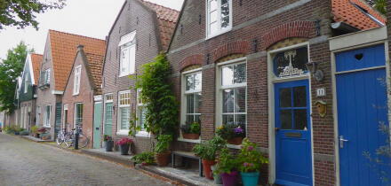 Quaint village houses with blooming flowers and plants in Edam, Netherlands, showcasing traditional Dutch architecture