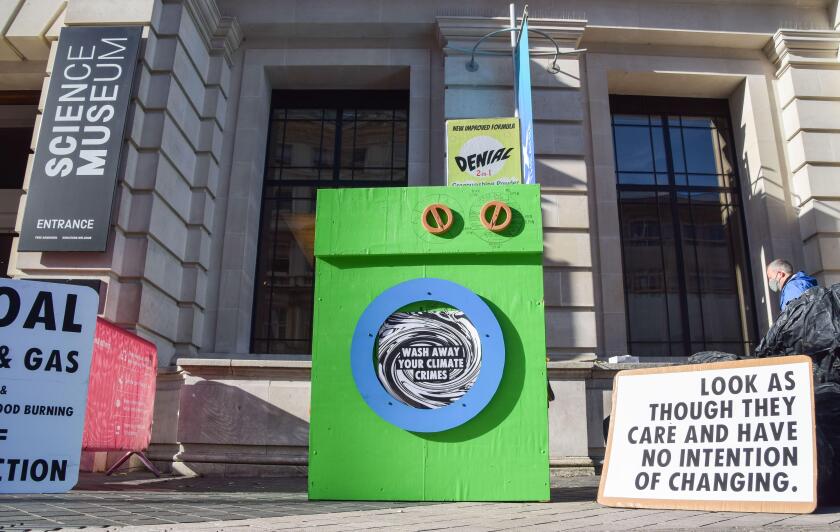 London, UK. 24th Oct, 2021. A 'greenwashing machine' and placards are seen during the protest outside the Science Museum. Extinction Rebellion activists gathered outside the museum in South Kensington in protest against the museum's 'greenwash' sponsorshi