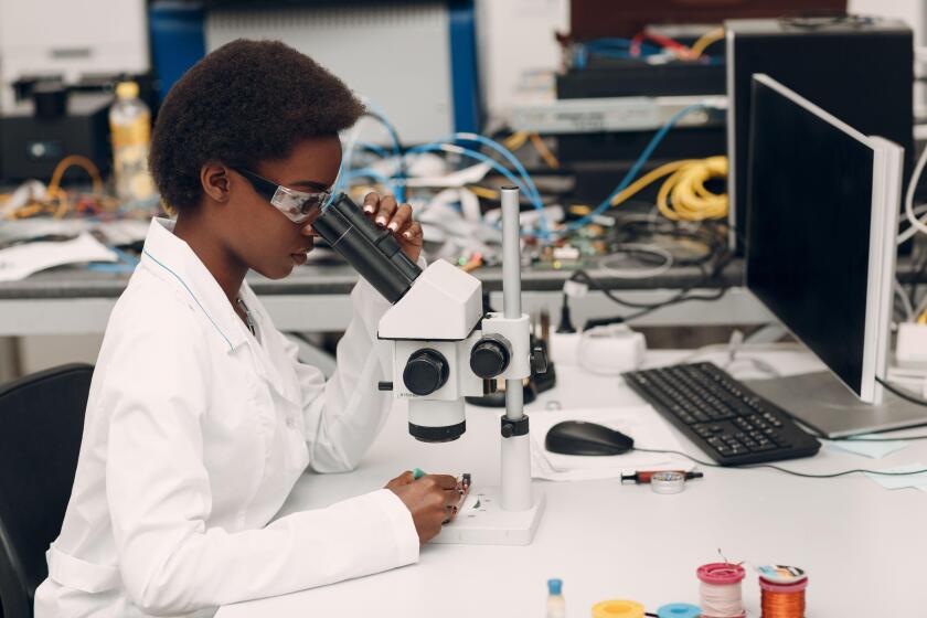 Scientist african american woman working in laboratory with electronic instruments