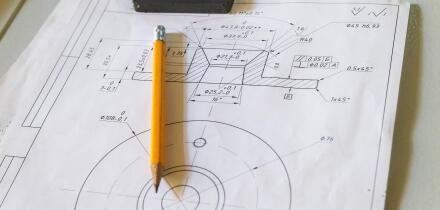 Drawing and pencil lies on a metal table at the factory