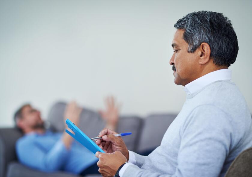 Talking is the best therapy. Shot of a therapist taking notes while listening to a patient during a counseling session.